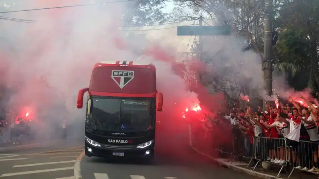 Ônibus do São Paulo FC chegando ao estádio em meio a sinalizadores da torcida