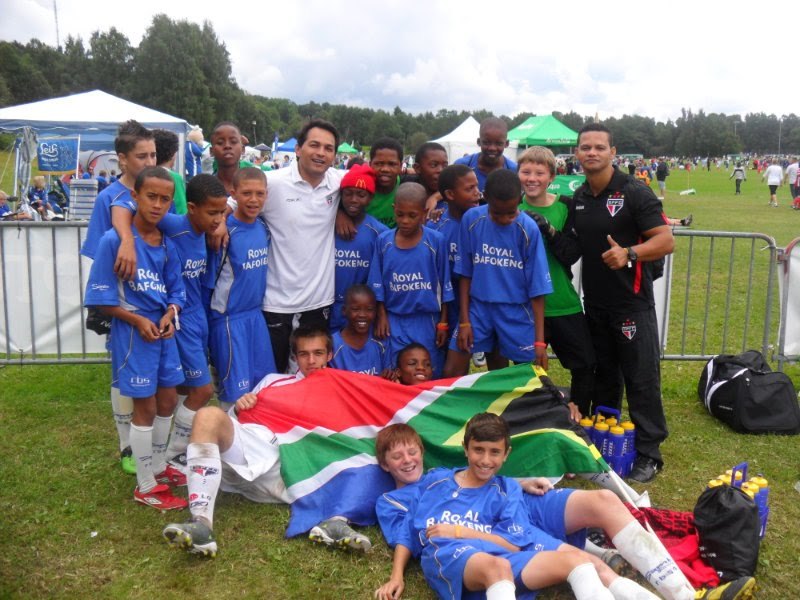 Jura ao lado de uma equipe juvenil sul-africana durante um torneio internacional de base