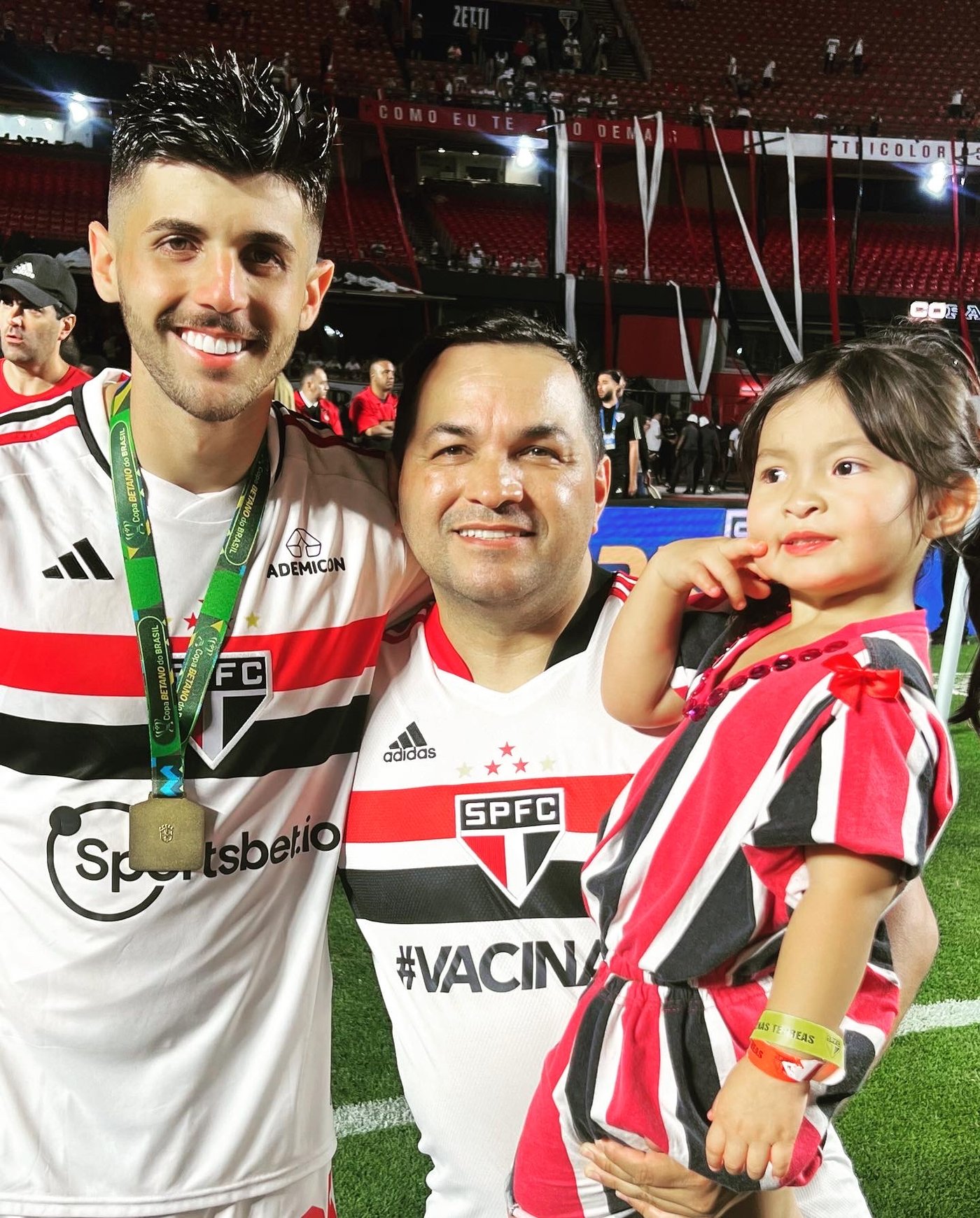 Jura com a filha no colo e um jogador do São Paulo FC medalhado no gramado do Morumbi