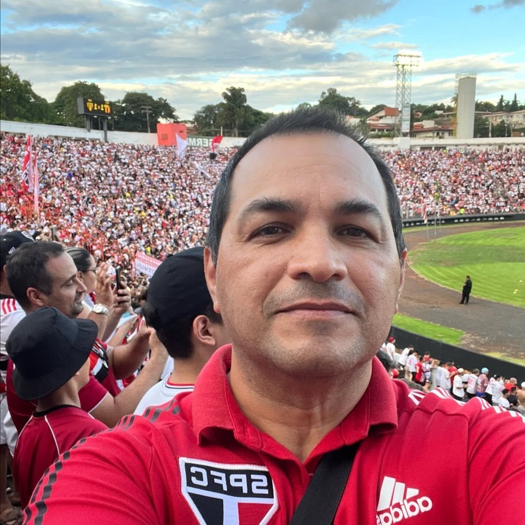 Jura de camisa do São Paulo FC na arquibancada, com a torcida tricolor lotando o estádio ao fundo