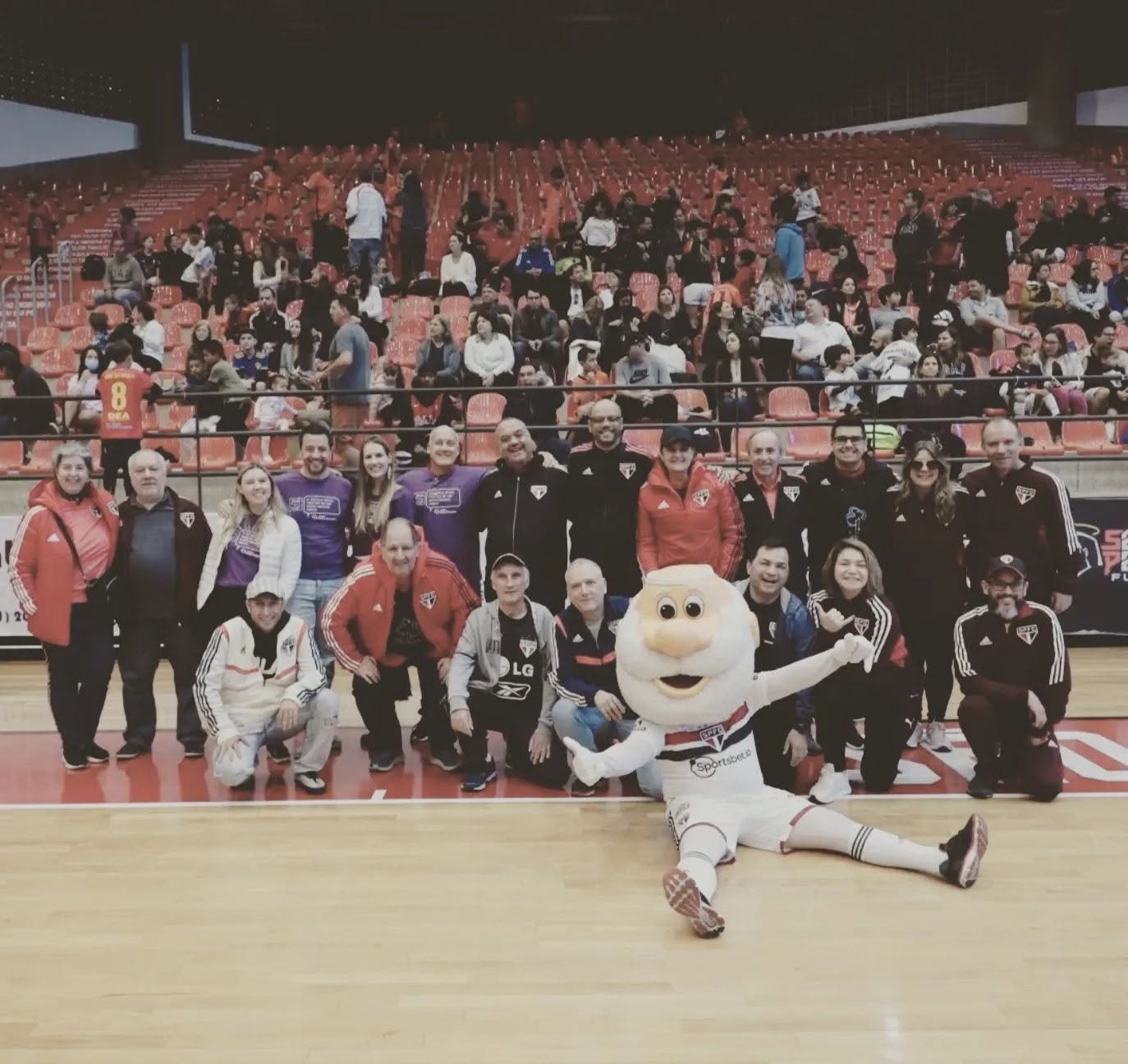 Jura com um grupo de associados e o mascote do São Paulo FC na quadra do clube